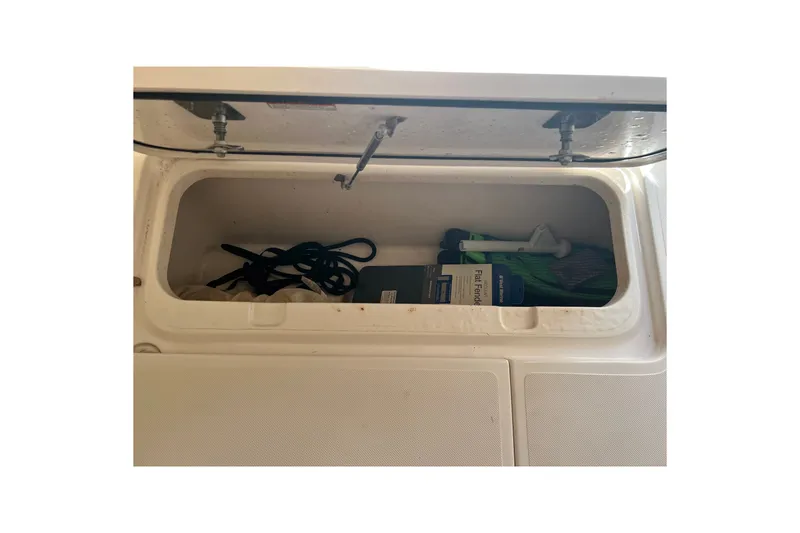 Slide: The Image of Storage compartment on a 2018 Pursuit OS 385 Offshore boat with various items inside. - 35