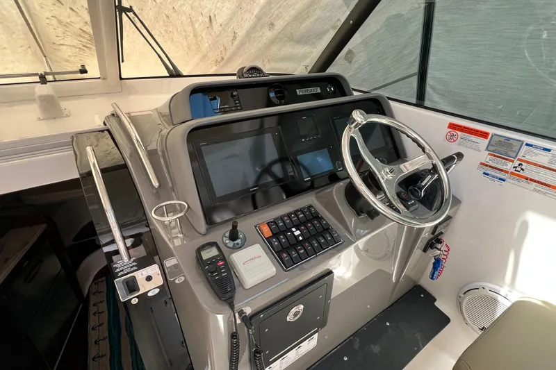 Slide: The Image of 2018 Pursuit OS 385 Offshore helm with modern controls and steering wheel. - 19