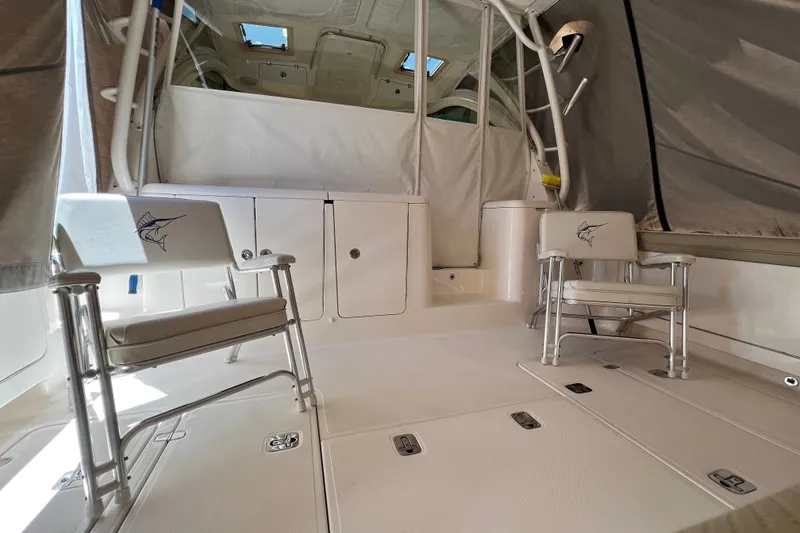 Slide: The Image of 2018 Pursuit OS 385 Offshore boat interior with fishing chairs and storage compartments. - 29