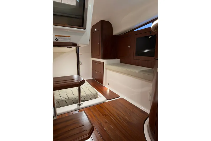 Slide: The Image of 2018 Pursuit OS 385 Offshore cabin interior with wood flooring and modern cabinetry. - 13