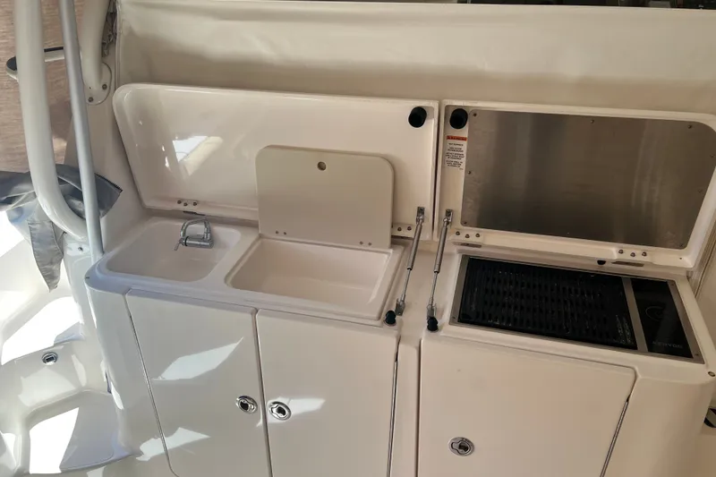 Slide: The Image of 2018 Pursuit OS 385 Offshore boat kitchen with sink and grill setup. - 28