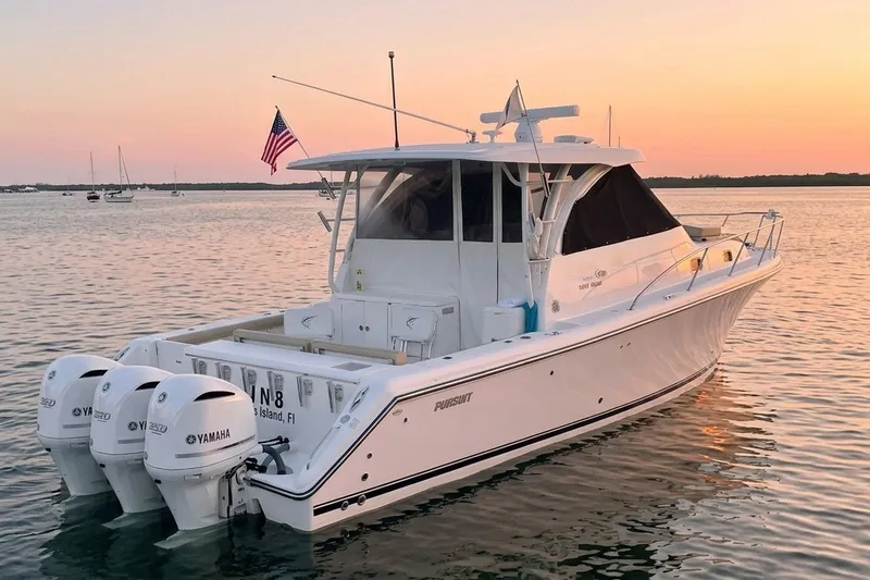 Slide: The Image of 2018 Pursuit OS 385 Offshore boat at sunset with triple Yamaha engines. - 1