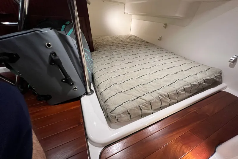 Slide: The Image of 2018 Pursuit OS 385 Offshore cabin with mattress and luggage on wooden floor. - 11