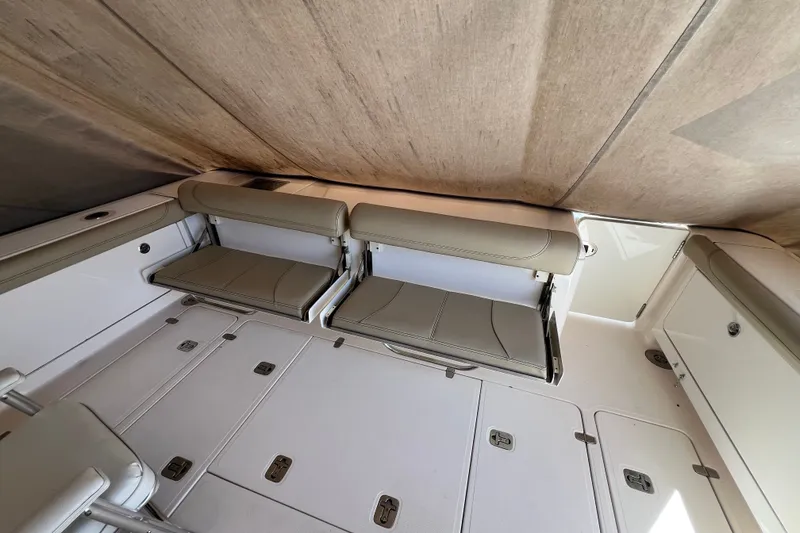 Slide: The Image of 2018 Pursuit OS 385 Offshore boat interior with foldable seating and storage compartments. - 30