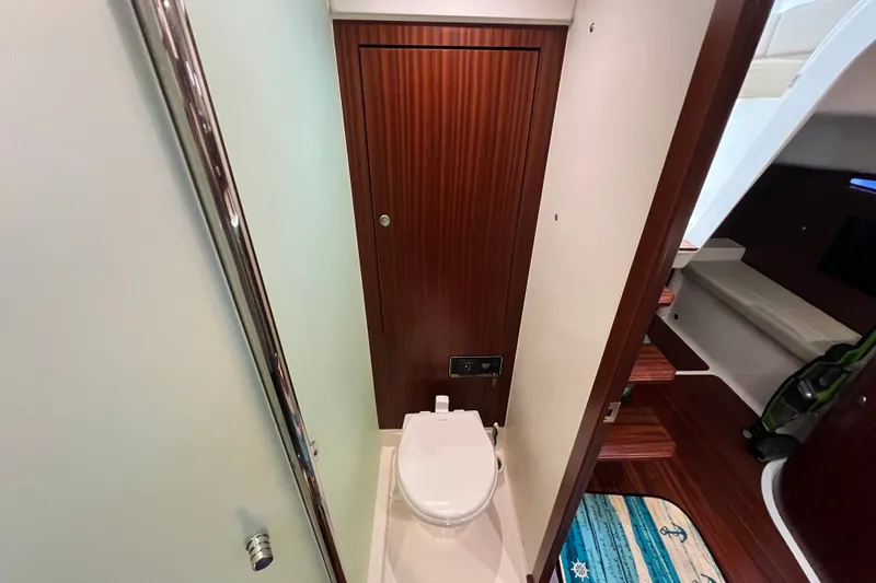 Slide: The Image of 2018 Pursuit OS 385 Offshore yacht bathroom with wooden door and modern toilet. - 18