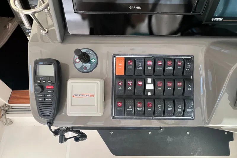 Slide: The Image of Control panel of a 2018 Pursuit OS 385 Offshore boat with switches and communication device. - 22
