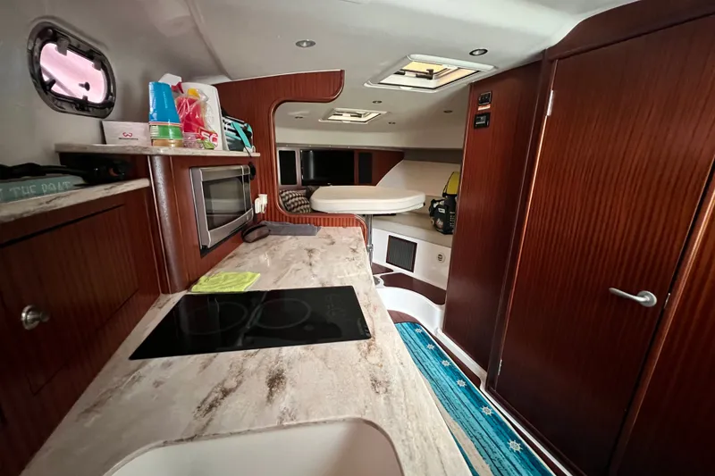 Slide: The Image of Interior of 2018 Pursuit OS 385 Offshore boat with kitchen and seating area. - 13