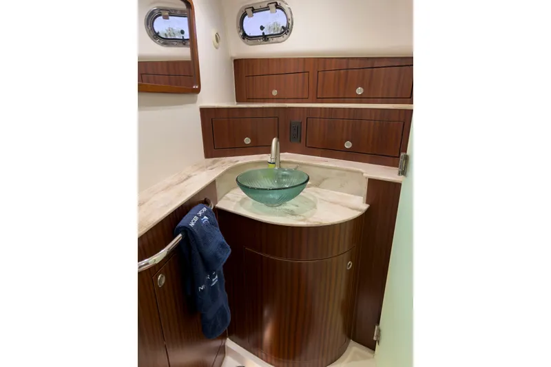 Slide: The Image of Luxurious 2018 Pursuit OS 385 Offshore bathroom with elegant wood cabinetry and glass vessel sink. - 19