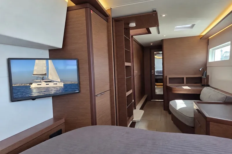 Slide: The Image of Luxurious interior of 2022 Lagoon 46 yacht with modern furnishings and a TV displaying a sailboat. - 31