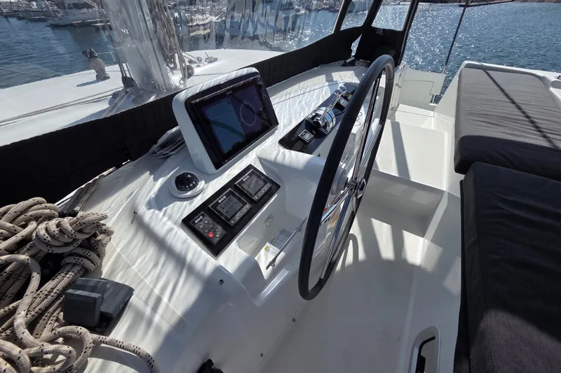 Slide: The Image of Helm station of 2022 Lagoon 46 catamaran with navigation equipment and steering wheel. - 16