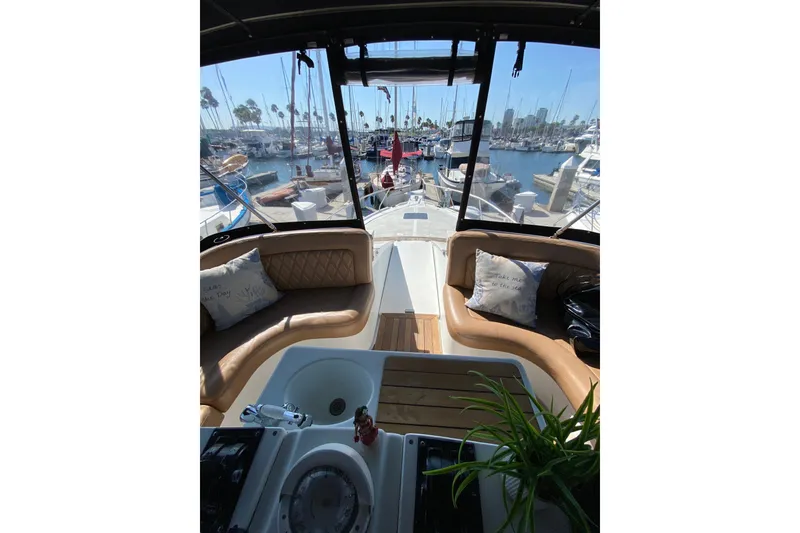 Slide: The Image of 1997 Mainship 40 Sedan Bridge interior with marina view, featuring comfortable seating and nautical decor. - 24