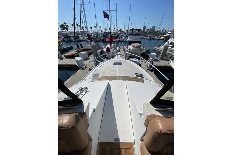 Slide: The Image of 1997 Mainship 40 Sedan Bridge yacht docked at marina, surrounded by sailboats under clear blue sky. - 23