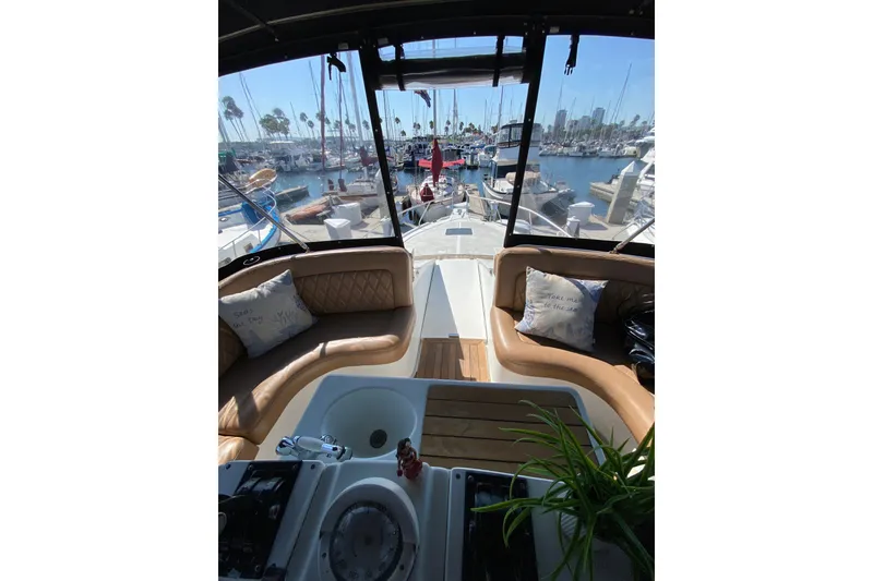 Slide: The Image of Interior view of 1997 Mainship 40 Sedan Bridge yacht at marina, featuring plush seating and helm. - 22