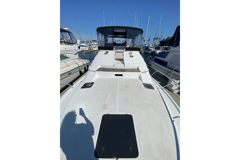 Slide: The Image of 1997 Mainship 40 Sedan Bridge yacht docked at marina, showcasing spacious deck and sleek design. - 27
