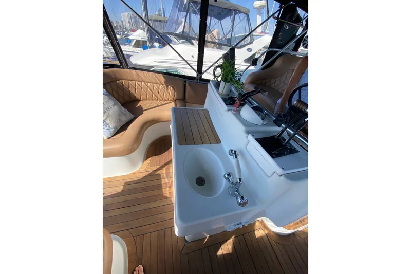 Slide: The Image of Interior of 1997 Mainship 40 Sedan Bridge with seating, sink, and helm controls. - 21