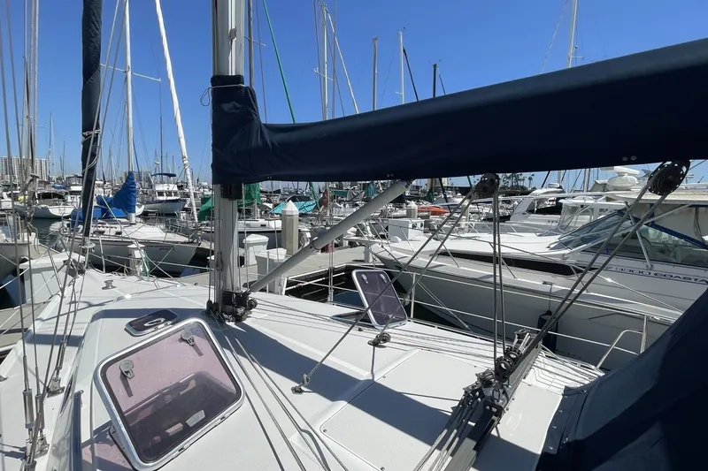 Slide: The Image of 2004 Catalina 350 sailboat docked in a marina, surrounded by other boats. - 18