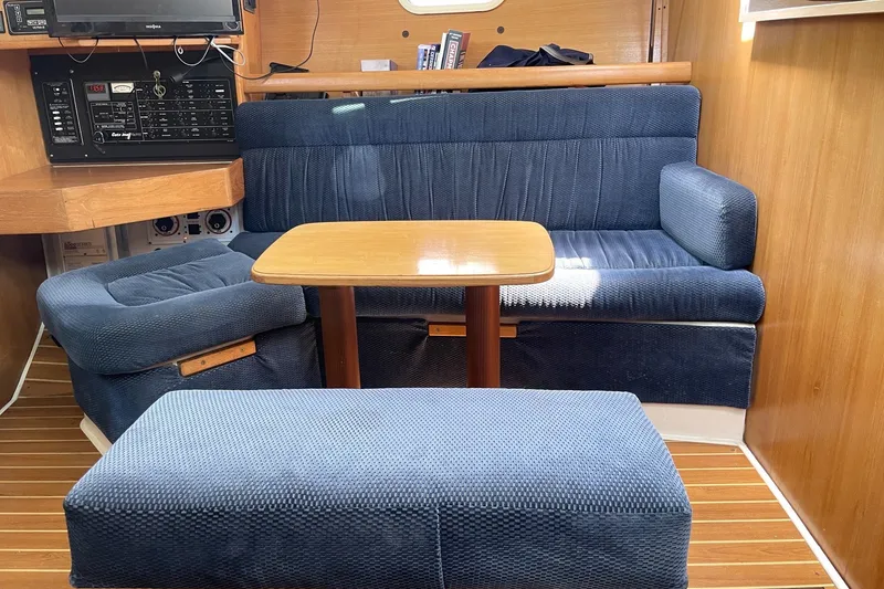 Slide: The Image of Interior of a 2004 Catalina 350 sailboat with blue seating and wooden table. - 5