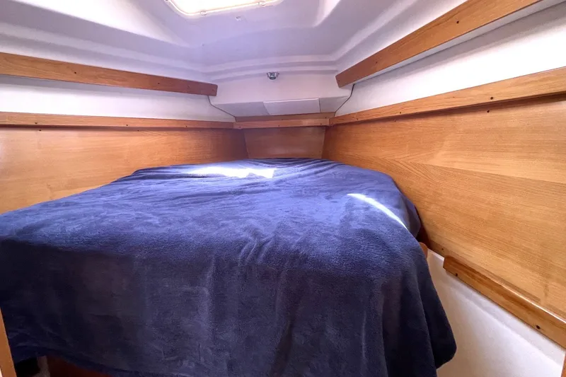 Slide: The Image of Cozy cabin interior of 2004 Catalina 350 sailboat with wooden accents and blue bedding. - 12