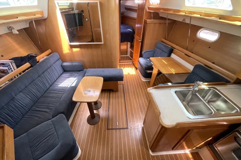 Slide: The Image of Interior of a 2004 Catalina 350 sailboat with cozy seating and wooden finishes. - 1
