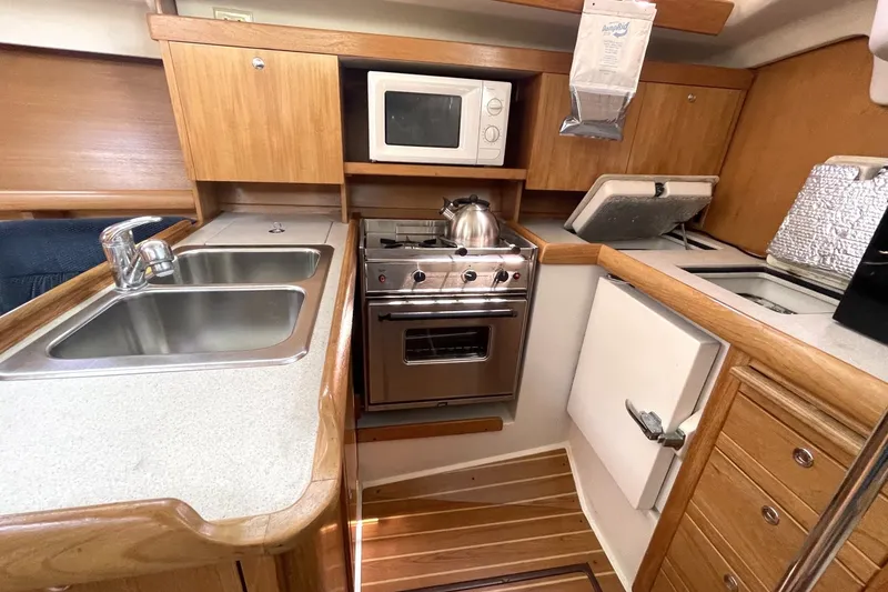 Slide: The Image of Compact kitchen in 2004 Catalina 350 sailboat with stove, sink, and microwave. - 2