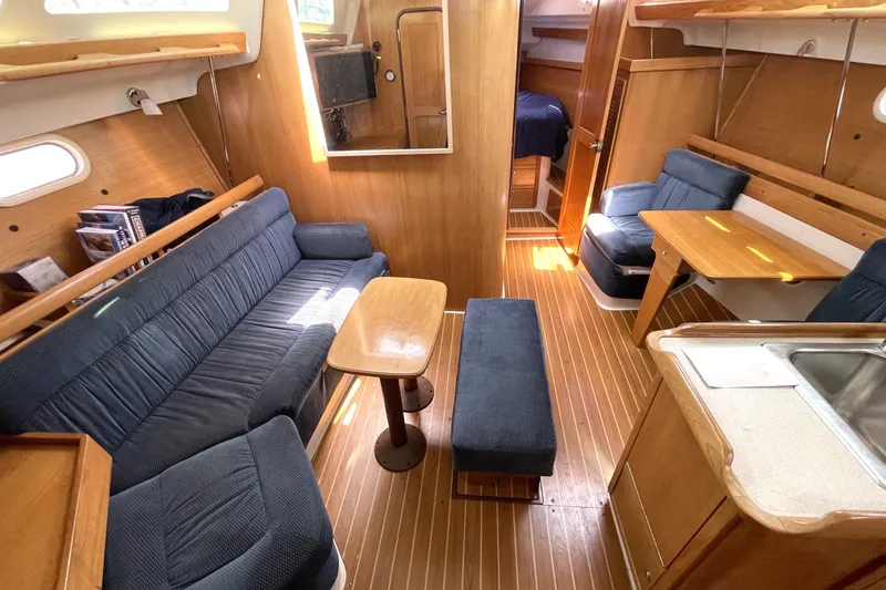 Slide: The Image of Interior of a 2004 Catalina 350 sailboat with cozy seating and wooden finishes. - 15