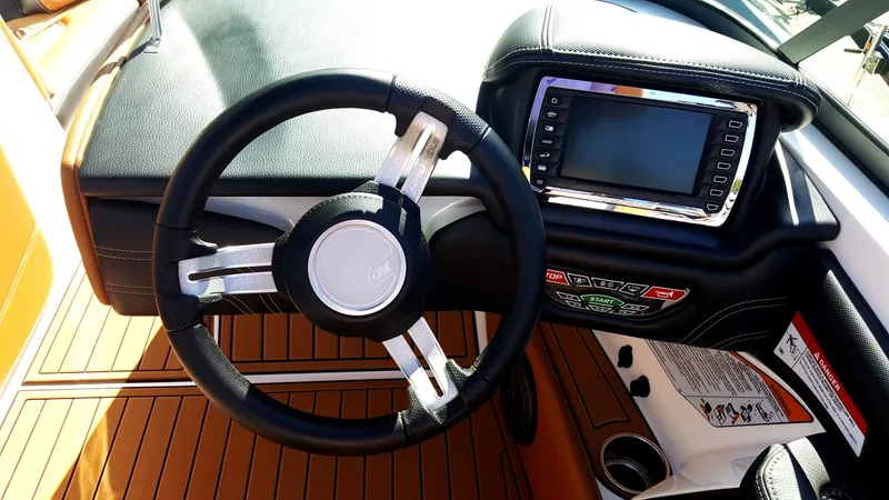 Slide: The Image of The image shows the cockpit of a 2017 Nautique Super Air Nautique 210 with a modern steering wheel and display. - 6