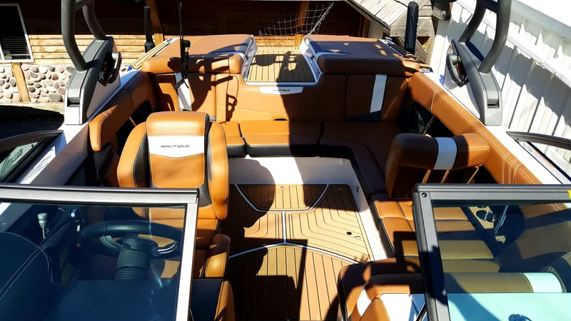 Slide: The Image of The image shows the interior of a 2017 Nautique Super Air Nautique 210 with brown leather seats. - 3