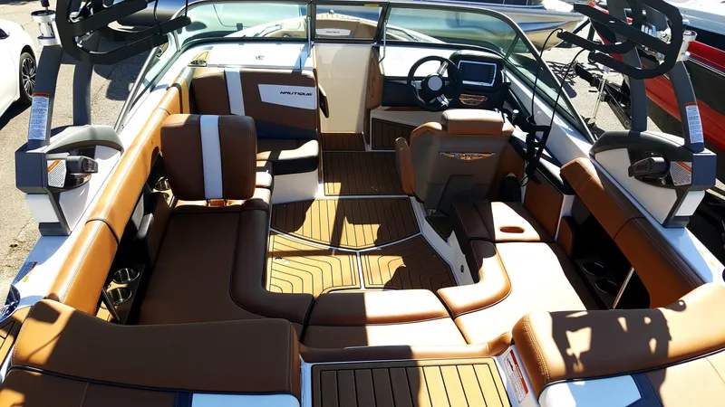 The Image of The image shows the interior of a 2017 Super Air Nautique 210 with brown seating and a modern cockpit. - 1
