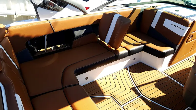 Slide: The Image of The image shows the interior of a 2017 Nautique Super Air Nautique 210 with brown leather seats. - 11