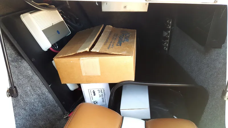 Slide: The Image of A storage compartment in the boat with boxes and electronic equipment, surrounded by gray carpet. - 9