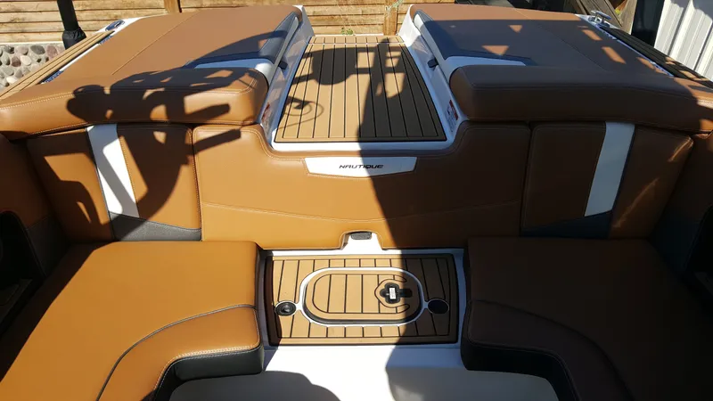 Slide: The Image of The image shows the stern of a 2017 Nautique Super Air Nautique 210 with brown upholstery. - 15