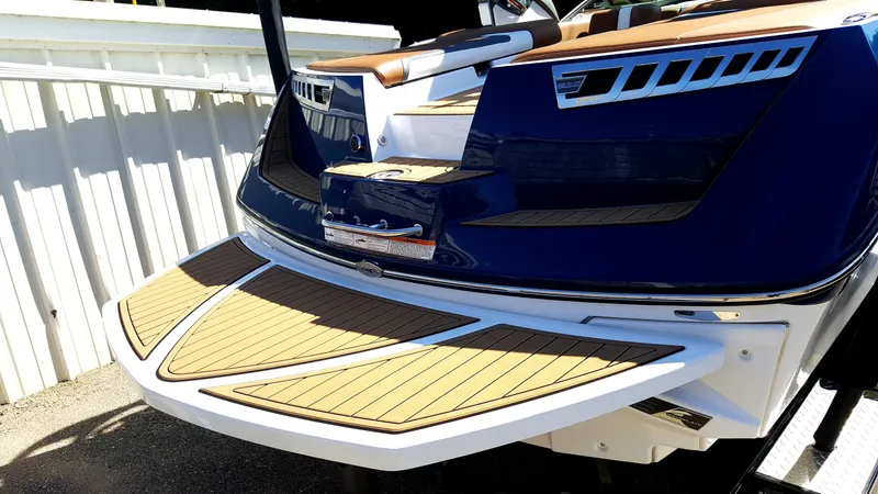 Slide: The Image of The image shows the rear of a 2017 Super Air Nautique 210 with a sleek swim platform. - 20