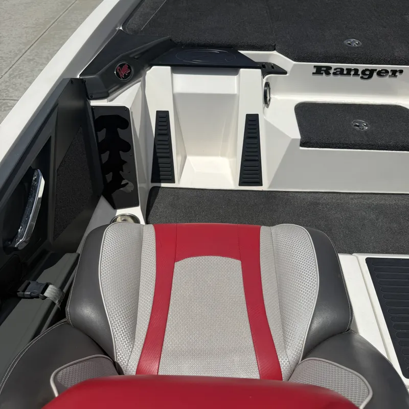 Slide: The Image of The image shows the interior of a 2019 Ranger Z518 boat with a red and gray seat. - 13