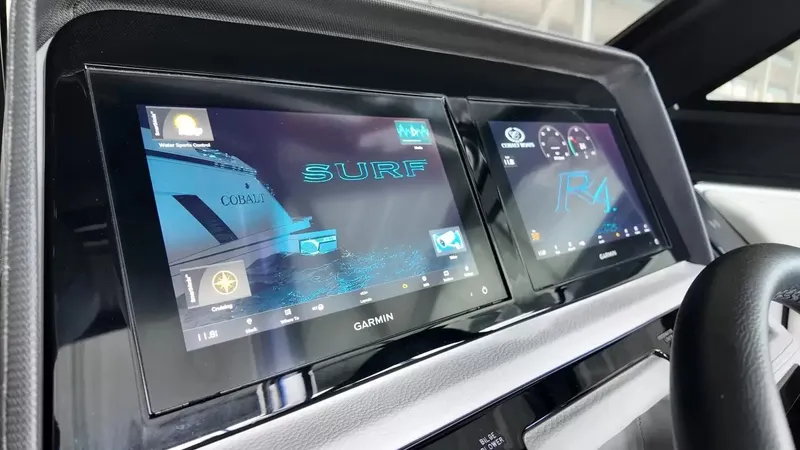 Slide: The Image of The image shows the dashboard of a Cobalt R4 Surf boat with two Garmin screens. - 19