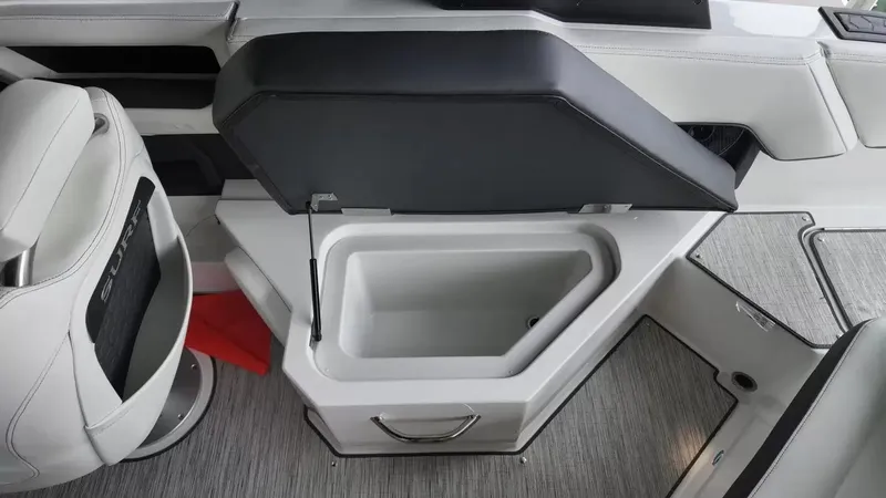 Slide: The Image of The image shows an open storage compartment on a 2026 Cobalt R4 Surf boat with gray flooring. - 48