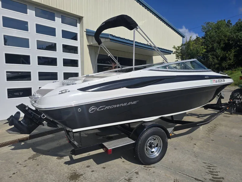 Slide: The Image of A 2016 Crownline 21 SS boat on a trailer in front of a garage. - 6