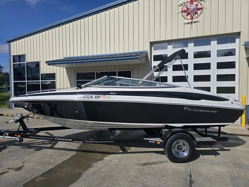 Slide: The Image of A 2016 Crownline 21 SS boat on a trailer in front of a building. - 2