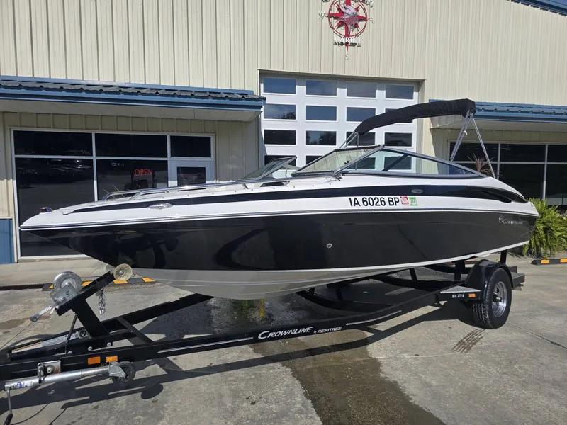 The Image of A black 2016 Crownline 21 SS boat on a trailer in front of a building. - 1