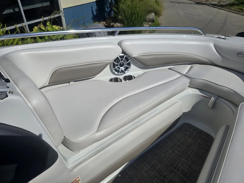 Slide: The Image of The image shows the cockpit of a 2016 Crownline 21 SS boat with beige upholstery and speakers. - 22
