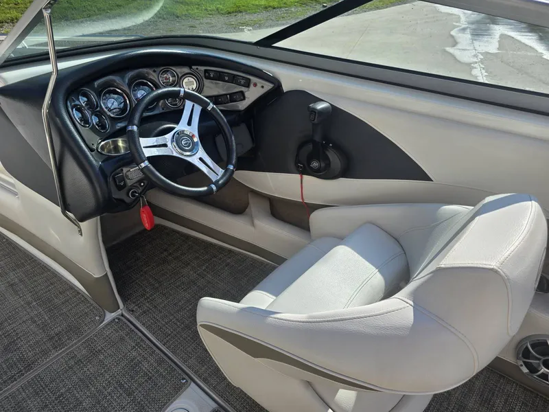 Slide: The Image of The image shows the cockpit of a 2016 Crownline 21 SS boat with a sleek steering wheel and instruments. - 14