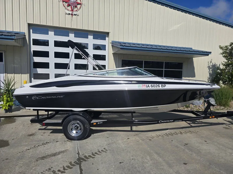Slide: The Image of A black and white 2016 Crownline 21 SS boat on a trailer in front of a building. - 5