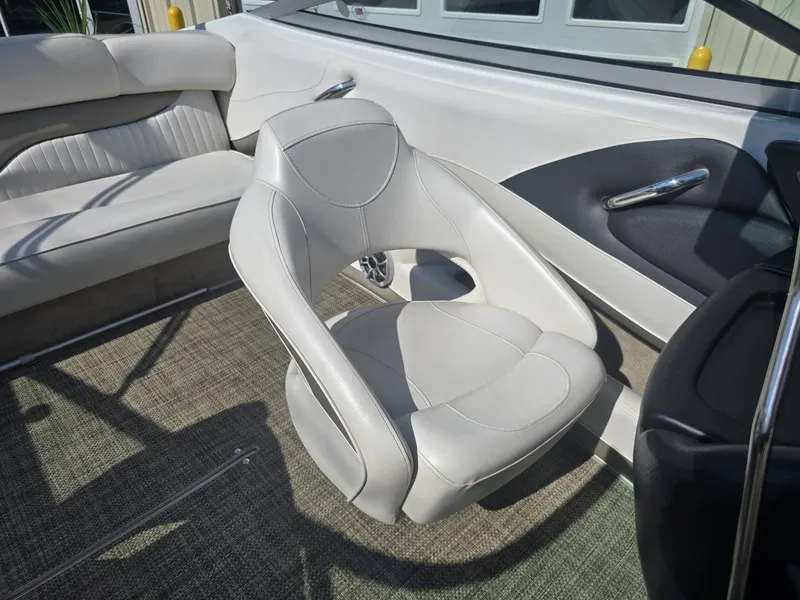 Slide: The Image of Interior of a 2016 Crownline 21 SS boat with white leather seats and carpeted floor. - 18