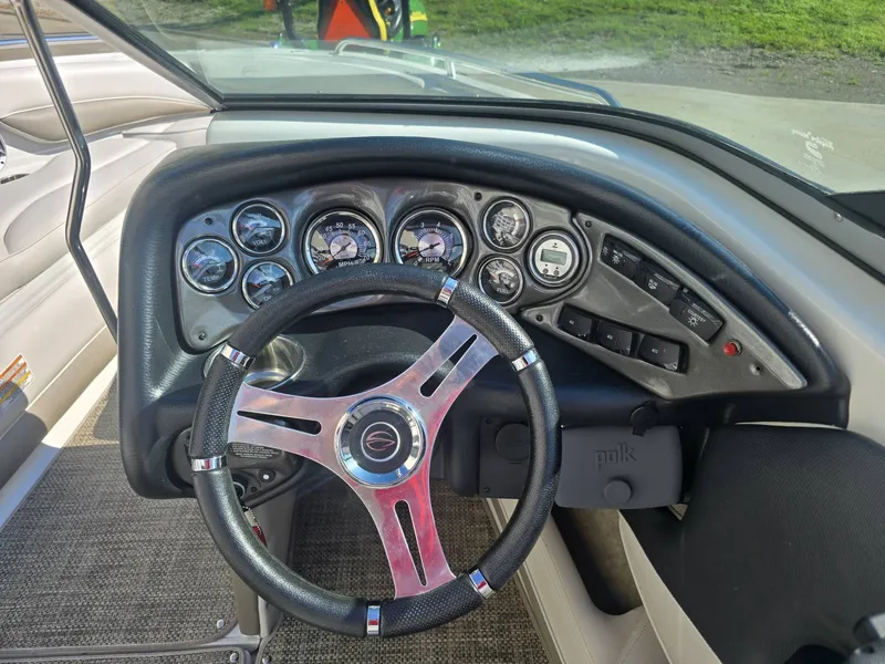 Slide: The Image of The image shows the dashboard of a 2016 Crownline 21 SS boat with multiple gauges and a steering wheel. - 15