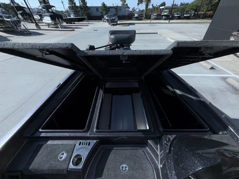 Slide: The Image of The image shows the open storage compartment of a 2018 Falcon F205 boat in a parking area. - 25