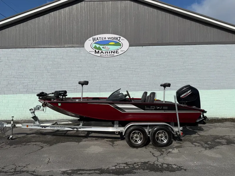 The Image of A red 2023 Lowe Stinger 178 boat on a trailer in front of a building. - 1