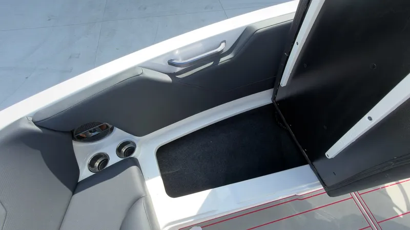 Slide: The Image of The image shows the interior of a 2021 MasterCraft NXT24 boat with gray upholstery and cup holders. - 21
