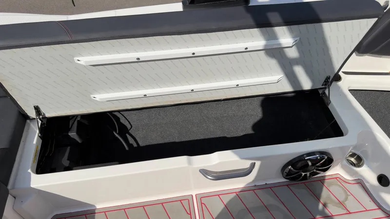 Slide: The Image of Open storage compartment in the boat with gray upholstery and speaker. - 15