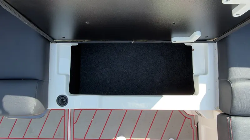 Slide: The Image of An open storage compartment on a boat with black carpet lining. - 14