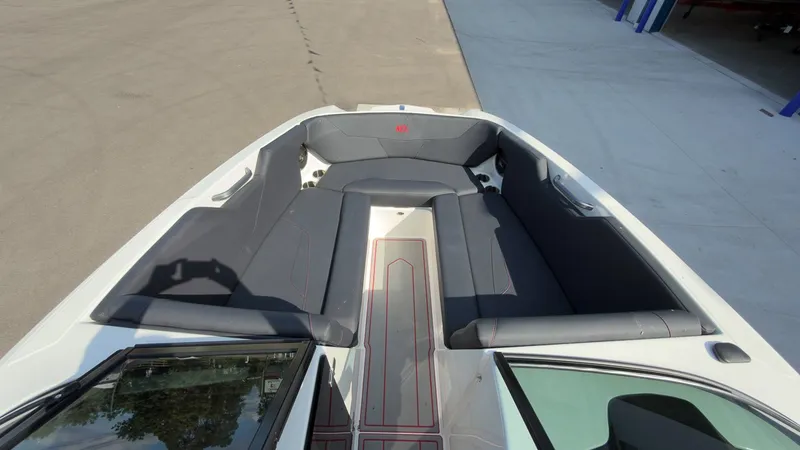 Slide: The Image of The image shows the bow area of a MasterCraft NXT24 boat with gray upholstery. - 19