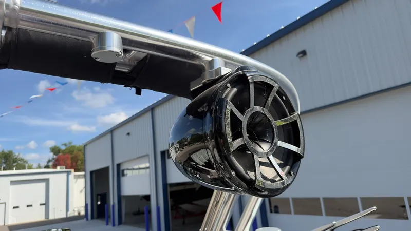 Slide: The Image of Close-up of a speaker on a boat with metal frame and building in the background. - 13